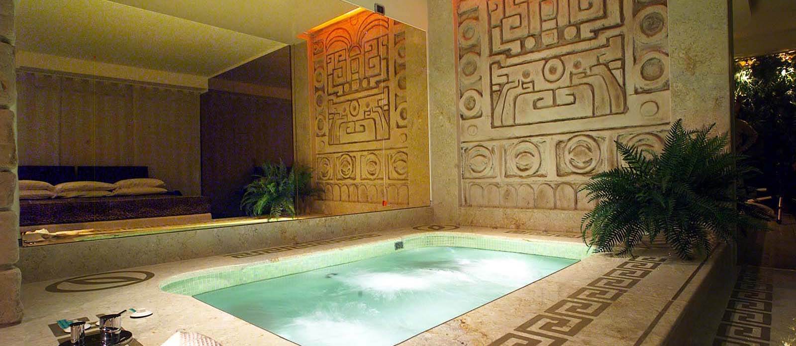 Motel K Senior Suite Maya vista sulla mini piscina idromassaggio di 3mq con letto matrimoniale che si intravede dallo specchio di fianco alla mini piscina camera a tema civiltà azteca