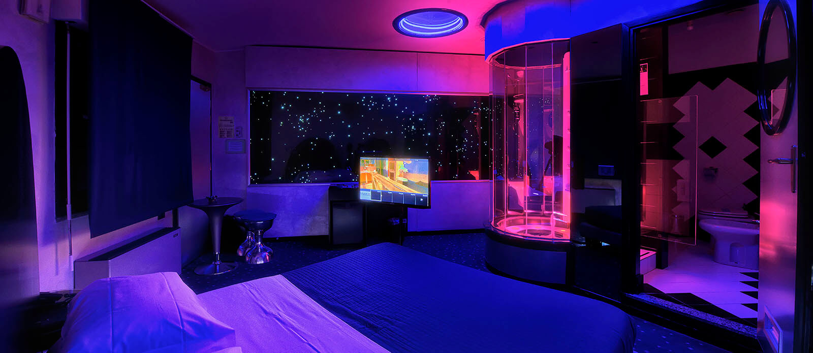 Motel K Junior Suite Planetaria vista su letto matrimoniale con doccia idromassaggio a vista davanti al letto camera a tema fantascientifico