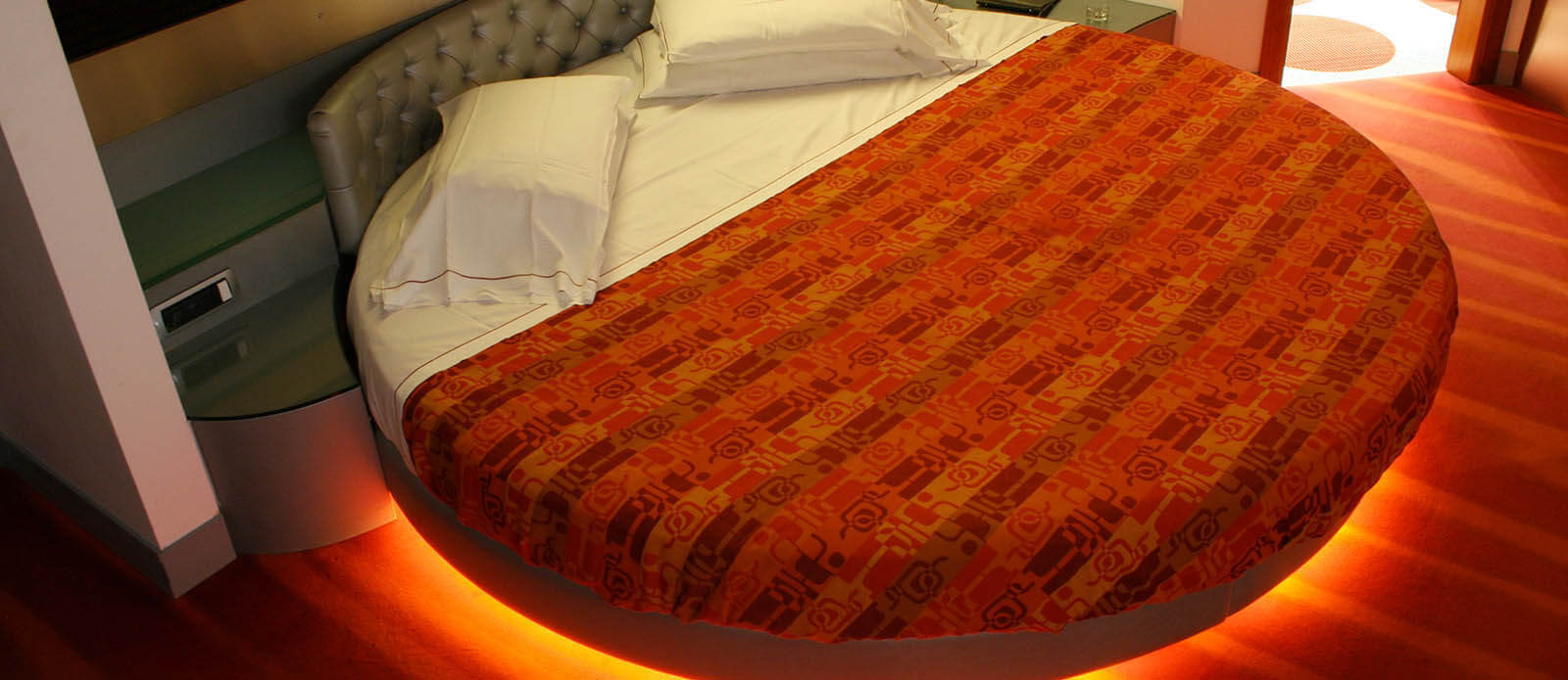 Motel K Senior Suite Luna dettaglio sull'illuminazione sotto il letto matrimoniale rotondo, camera a tema chiaro di Luna