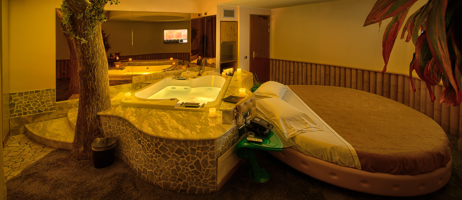 Motel K Senior Suite Natura vista sulla vasca idromassaggio doppia dietro al letto rotondo matrimoniale, servizio candele in suite camera a tema naturalistico
